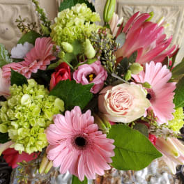 Pink gerbera daisies and roses with green hydrangeas in a bouquet