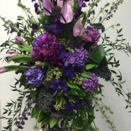 Tall purple floral spray with cascading greenery
