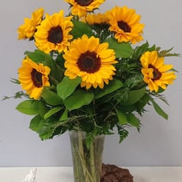 Bouquet of yellow sunflowers in a clear glass vase