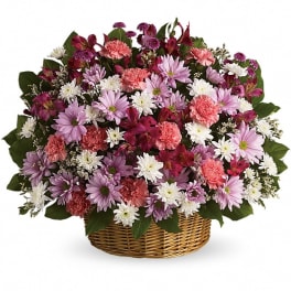 Mixed pink, white, and purple flowers in a wicker basket