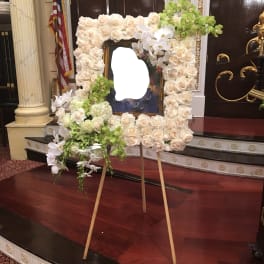 Large floral easel display of white roses and orchids