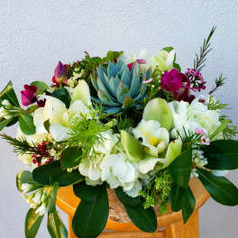 Mixed bouquet with white orchids, hydrangeas, and a blue succulent centerpiece