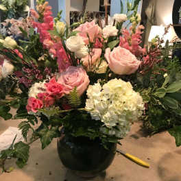 Mixed pink and white flower arrangement in a black vase