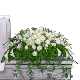 Large white floral casket spray with roses and calla lilies on a silver casket