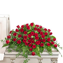 Large red rose casket spray on a light-colored casket