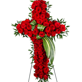 Cross-shaped arrangement of red roses with green foliage