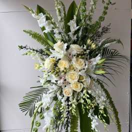 Tall white floral standing spray with roses and orchids