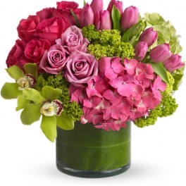 Pink roses, tulips, and hydrangea in a green glass vase