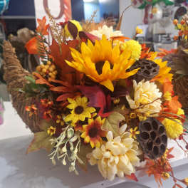 Autumn floral arrangement with sunflowers and cream mums in a woven basket