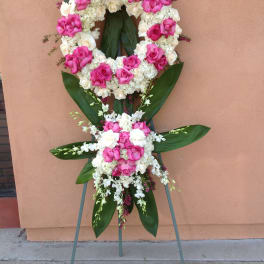 Standing floral wreath of pink and white roses on an easel