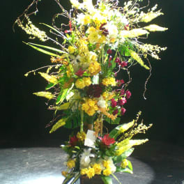 Tall floral arrangement with yellow and white blooms in a vase