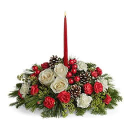 Holiday centerpiece with red candle, white roses, pinecones, and red accents