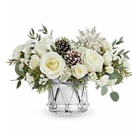 White roses and pinecones arranged in a clear glass vase