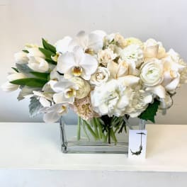White floral arrangement in a clear rectangular vase