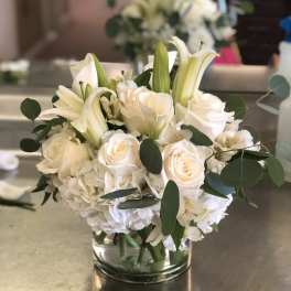 White roses and lilies arranged in a glass vase