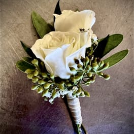 White rose boutonniere with green buds and leaves