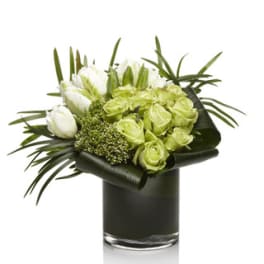 Green and white bouquet in a dark glass vase