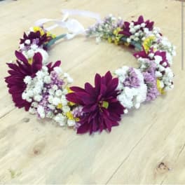 Purple and white floral lei on a wooden surface