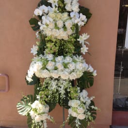 Tall white floral standing spray with roses and orchids