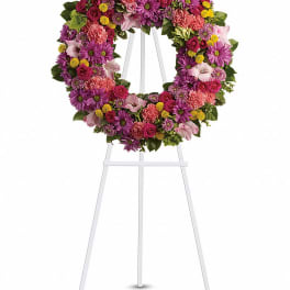 Colorful floral wreath on a white easel stand