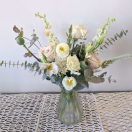 White and blush bouquet in a clear glass vase