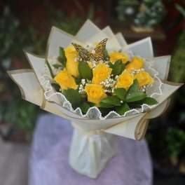 Bouquet of yellow roses wrapped in cream paper