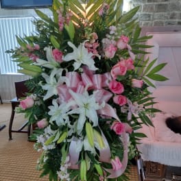 Large standing floral spray with pink roses and white lilies on an easel