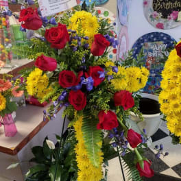 Tall floral spray with red roses, yellow chrysanthemums, and purple accents