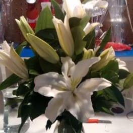 White lilies arranged in a clear glass vase