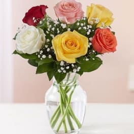 Bouquet of multicolored roses in a clear glass vase