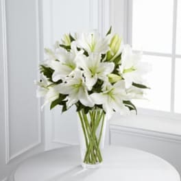 White lilies arranged in a clear glass vase
