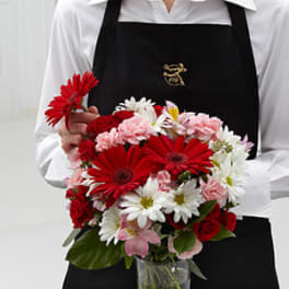 Bouquet of red, white, and pink flowers in a clear vase