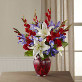 Bouquet of red, white, and purple flowers in a red glass vase