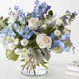 Blue and white flower arrangement in a clear glass vase