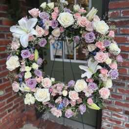 Pastel floral wreath with roses and lilies on a stand