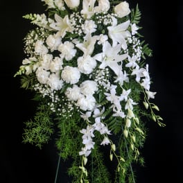 White funeral spray with roses, lilies, orchids, and carnations