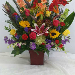Tall mixed flower arrangement in a burgundy vase
