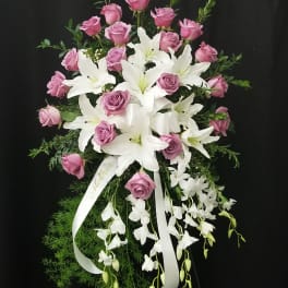 Pink roses and white lilies in a cascading floral spray with ribbon
