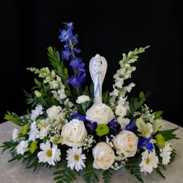 White and blue floral arrangement with a central angel figurine