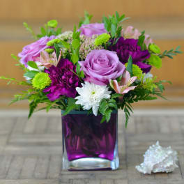 Lavender and purple bouquet in a square glass vase