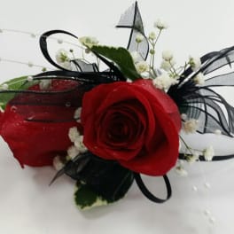 Red rose corsage with black ribbon and white baby's breath