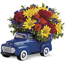 Blue toy truck filled with colorful flowers