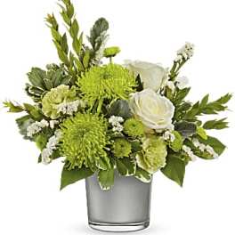 Green and white floral arrangement in a clear glass vase