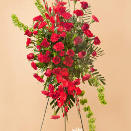 Tall red floral standing arrangement with roses and carnations on a metal easel