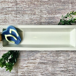 Rectangular white serving tray with a small decorative succulent and flip-flop accents
