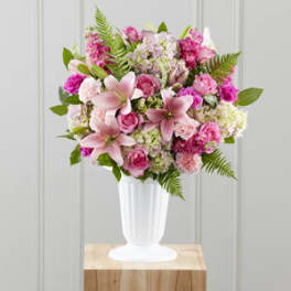 Pink mixed flower bouquet in a white pedestal vase
