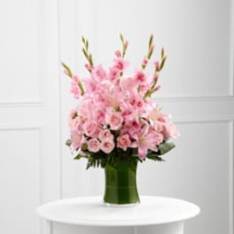 Pink floral arrangement in a green glass vase