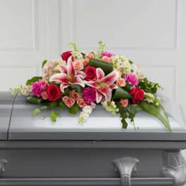 Casket spray with pink lilies and red roses