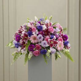 Large mixed bouquet of pink, purple, and white flowers in a tall gray vase
