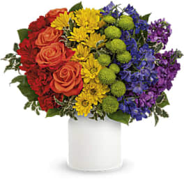 Colorful bouquet of roses, daisies, and pompons in a white vase